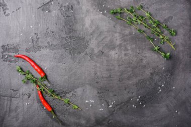 Kırmızı biber ve gri beton arka planda taze kekik.