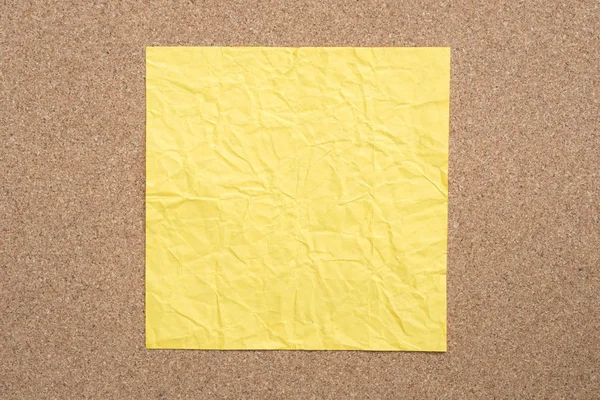 Nota de papel arrugado amarillo sobre fondo de corcho — Foto de Stock