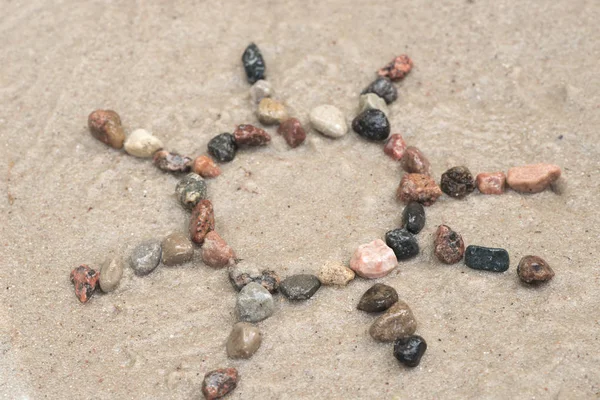 Pebble sun sign on sand — Stock Photo, Image