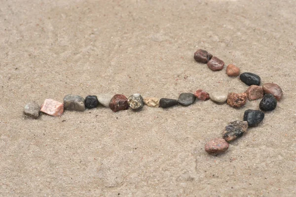 砂の上の小石矢印記号 — ストック写真