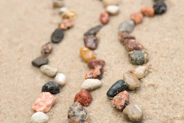 Pebble  wave pattern on sand selective focus — Stock Photo, Image