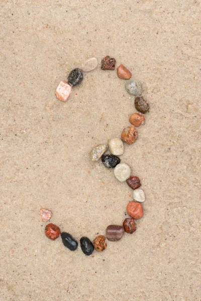 Pebble 3 number  on sand selective focus — Stock Photo, Image