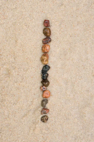 Pebble i letter  on sand — Stock Photo, Image