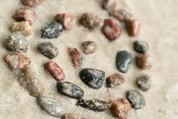 Símbolo de hélice de seixo em foco seletivo de areia — Fotografia de Stock