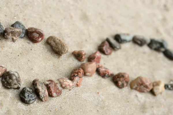 Pebble infinity symbol on sand  selective focus — Stock Photo, Image