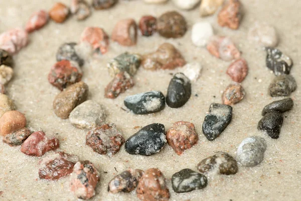 Pebble concentric circles on sand  selective focus — Stock Photo, Image