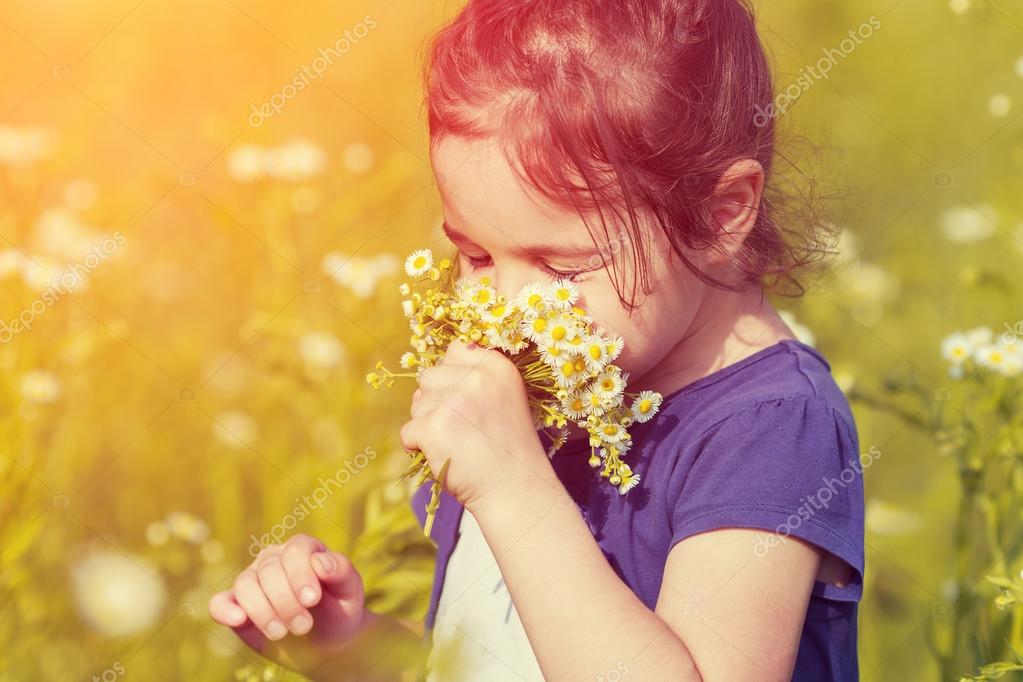 Little girl sniffs flowers Stock Photo by ©vvvita 125512044
