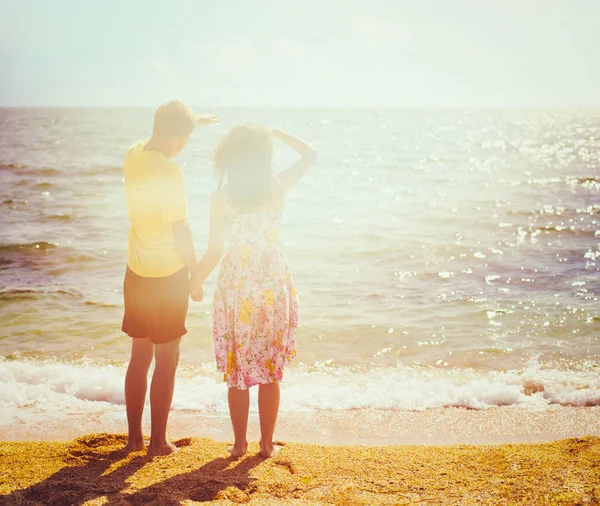 Jeune couple debout sur la plage — Photo