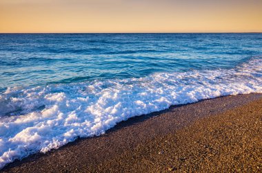 Çakıl plaj gün batımında