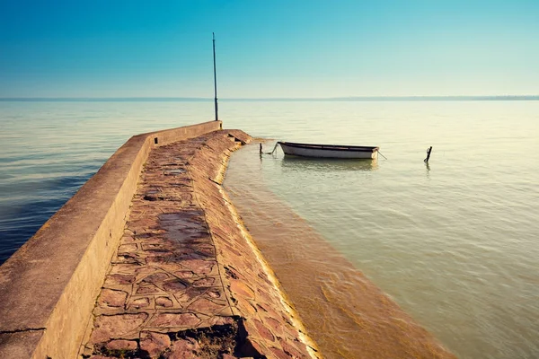 Morning on the lake. Boat near pier