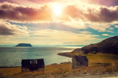 Bulutlu dramatik gökyüzü ve tekne garaj ile fiyort. Balık tutma evi. Gün batımında güzel doğa Norveç.