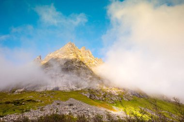 Dağın tepesinde, bulutların arasında.