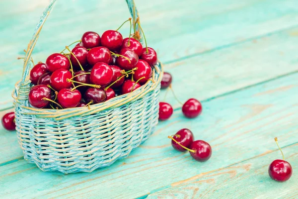 Sweet red fresh cherries in a basket on wooden grunge table