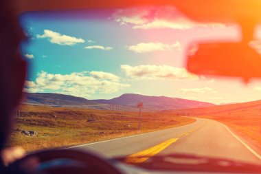 Gün batımında dağ yolda arabayı. Ön cam görüntüleyin. Norveç'in Doğa