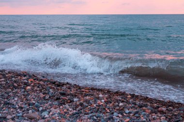 Çakıl taşları deniz plaj gün batımında
