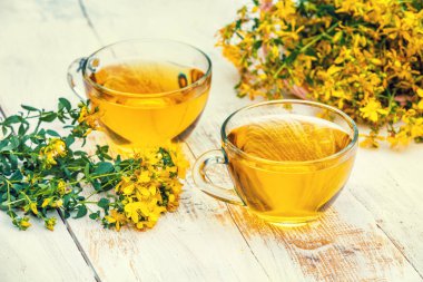 Hypericum bitkisel (Tutsan) çay ahşap grunge masada iki bardak