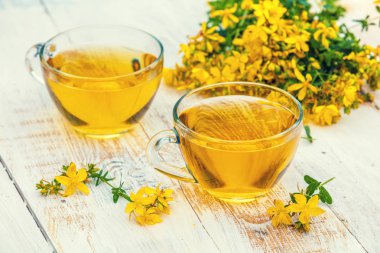 Hypericum bitkisel (Tutsan) çay ahşap grunge masada iki bardak