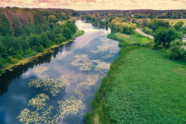 Kırsal doğa manzarası. Bulutlu gökyüzünün yansıması olan göl. Güzel yaz doğası