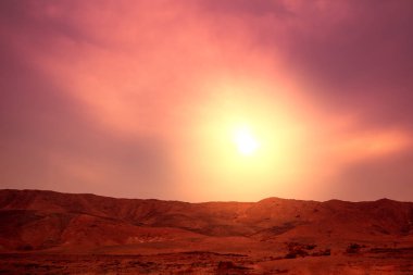 Dağ doğa manzarası. Akşamları çöl. Dağlarda turuncu gün batımı. Gün batımına karşı dağ sırtı manzarası. Doğa arkaplanı