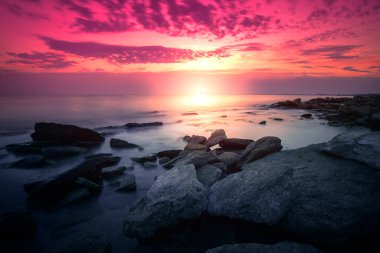 Şafakta vahşi kayalık plaj. Uzun pozlama