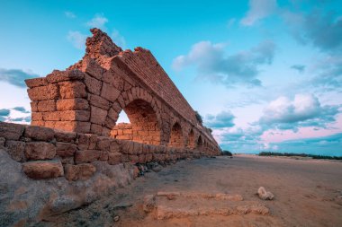 Günbatımında Caesarea antik kentinde su kemeri. Yaratıcı renk