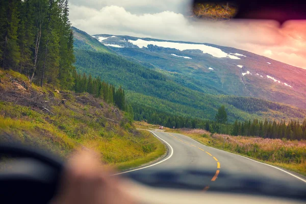 Driving a car on winding mountain road. Road among mountains, landscape. Beautiful nature of Norway.