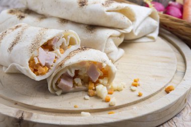 Kahvaltıda yumurtalı burrito, çedar peyniri, mikroyeşillik ve kızarmış mu