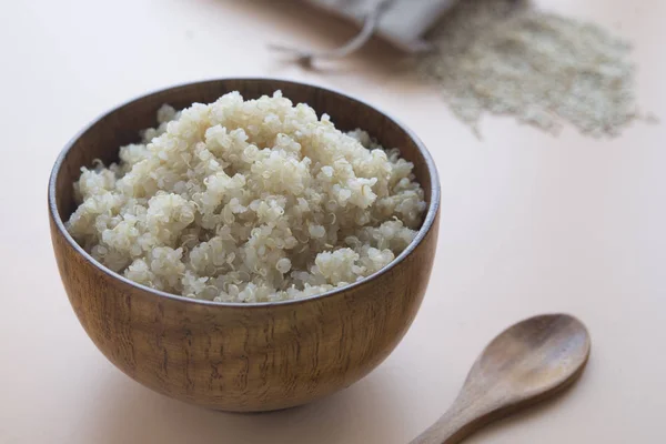 Quinoa gătită în castron și lingură de lemn pe fundal maro — Fotografie, imagine de stoc