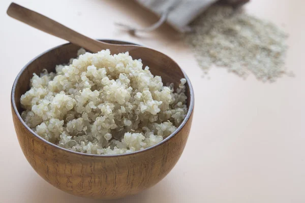 Quinoa gătită în castron și lingură de lemn pe fundal maro — Fotografie, imagine de stoc