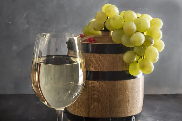 The still life with white wine, glass and old barrel Stock Picture