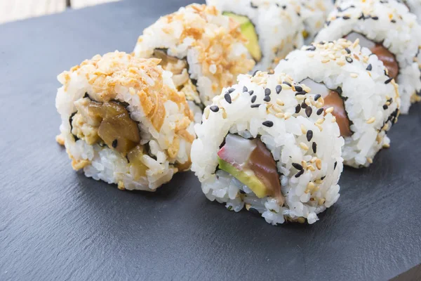 Rollos de sushi en un plato de pizarra — Foto de Stock