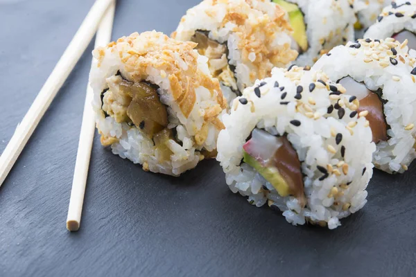 Rollos de sushi en un plato de pizarra — Foto de Stock