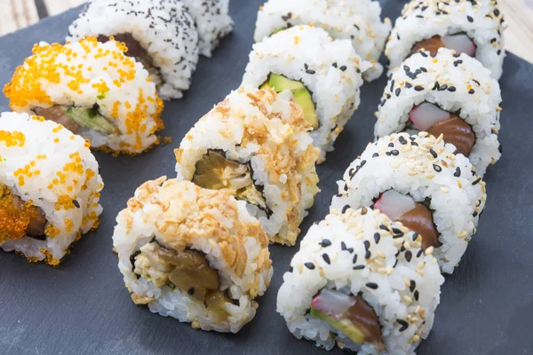 Rollos de sushi en un plato de pizarra — Foto de Stock