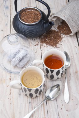 İki fincan 1 siyah çaydanlık rooibos ve diğer rezene.