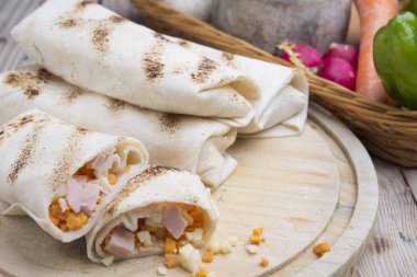 Kahvaltıda yumurtalı burrito, çedar peyniri, mikroyeşillik ve kızarmış mu