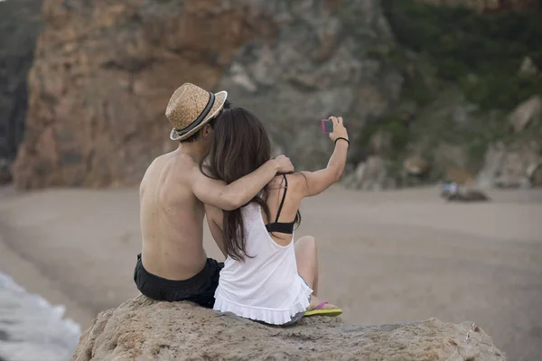 Pareja feliz tomando una foto en una playa en vacaciones — Foto de Stock