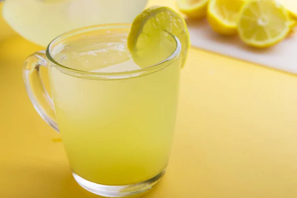 Agua y limón en fondo amarillo — Foto de Stock