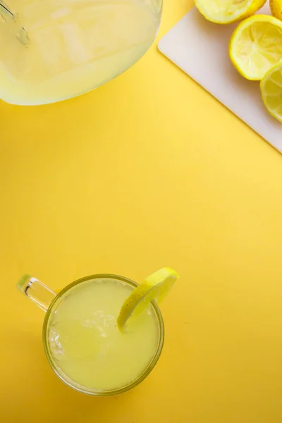 Acqua e limone su fondo giallo — Foto Stock