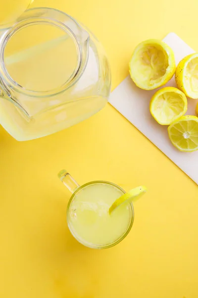 Água e limão em fundo amarelo — Fotografia de Stock