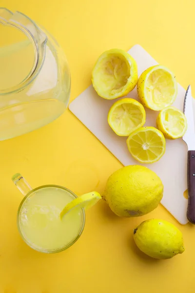 Agua y limón en fondo amarillo —  Fotos de Stock