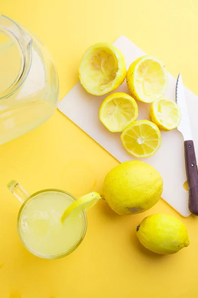 Agua y limón en fondo amarillo —  Fotos de Stock