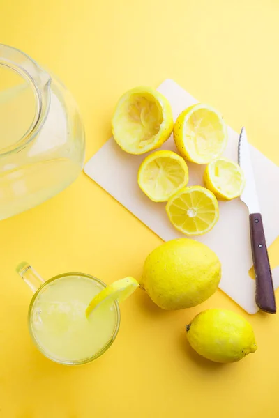 Вода и лимон на желтом фоне — стоковое фото