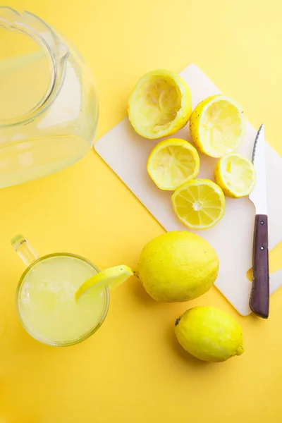 Agua y limón en fondo amarillo —  Fotos de Stock