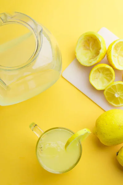 Agua y limón en fondo amarillo —  Fotos de Stock