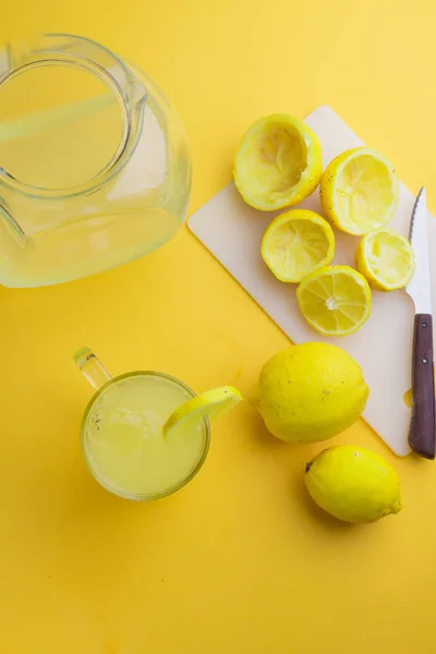 Agua y limón en fondo amarillo — Foto de Stock