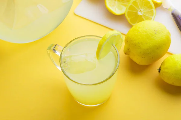 Vatten och citron i gul bakgrund — Stockfoto