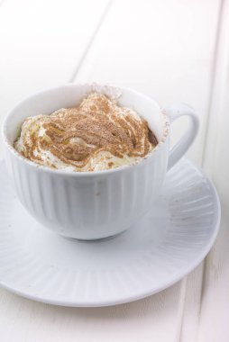 Sıcak çikolata ile süslenmiş çırpılmış krema ve kakao tozu.