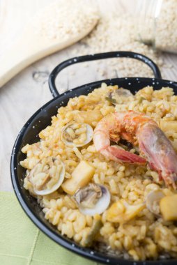 Ahşap bir arka plan üzerinde deniz ürünleri ile Sebze paella