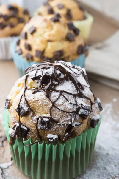 Falling sweet sugar on chocolate muffins — Stock Photo, Image