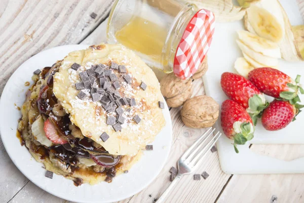 Pfannkuchen mit Beeren, Früchten, Schokolade, Pinienkernen und Honig auf — Stockfoto